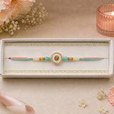 Peach and Blue Om Rakhi in Gold Finish For Brother