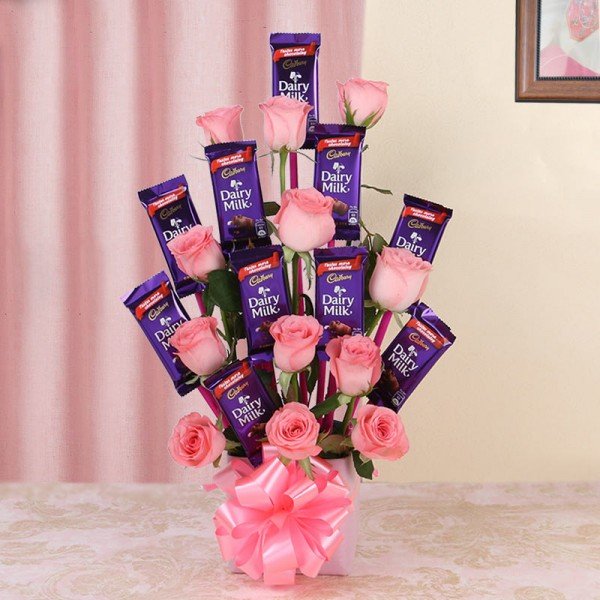 Glass Vase Arrangement Of 12 Pink Roses And 10 Dairy Milk Chocolates (13Gms Each)