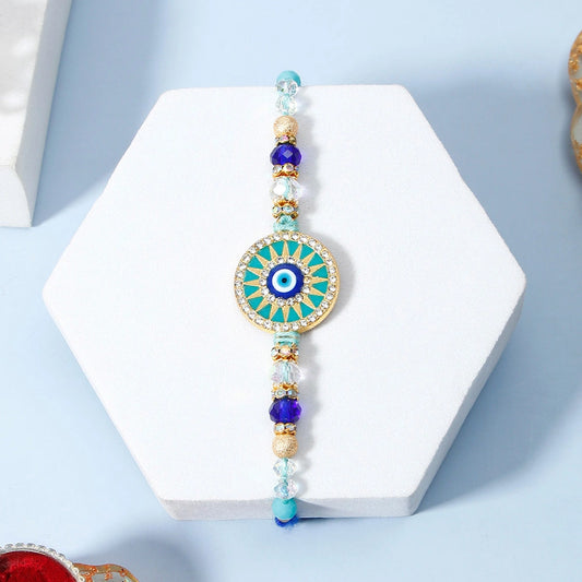 Turquoise Sunburst Evil Eye Designer Rakhi & UXR Royal Life Perfume Gift Set