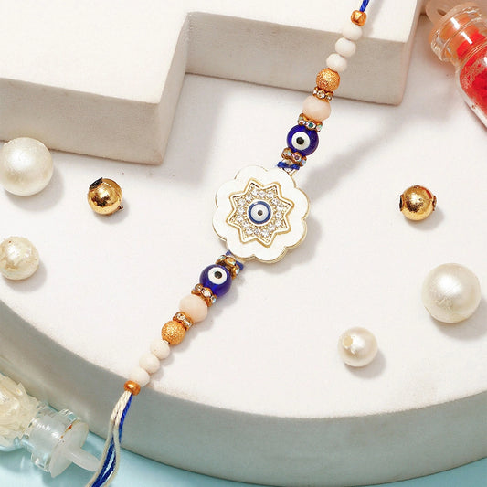 Ivory Flower Evil Eye Rakhi & UXR Royal Life Perfume Mug Set