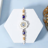 Ivory Flower Evil Eye Rakhi & UXR Royal Life Perfume Gift Set