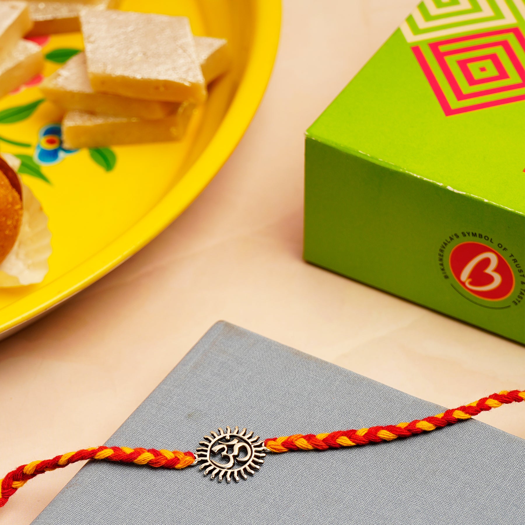 Divine Om Silver Rakhi with Kaju Barfi