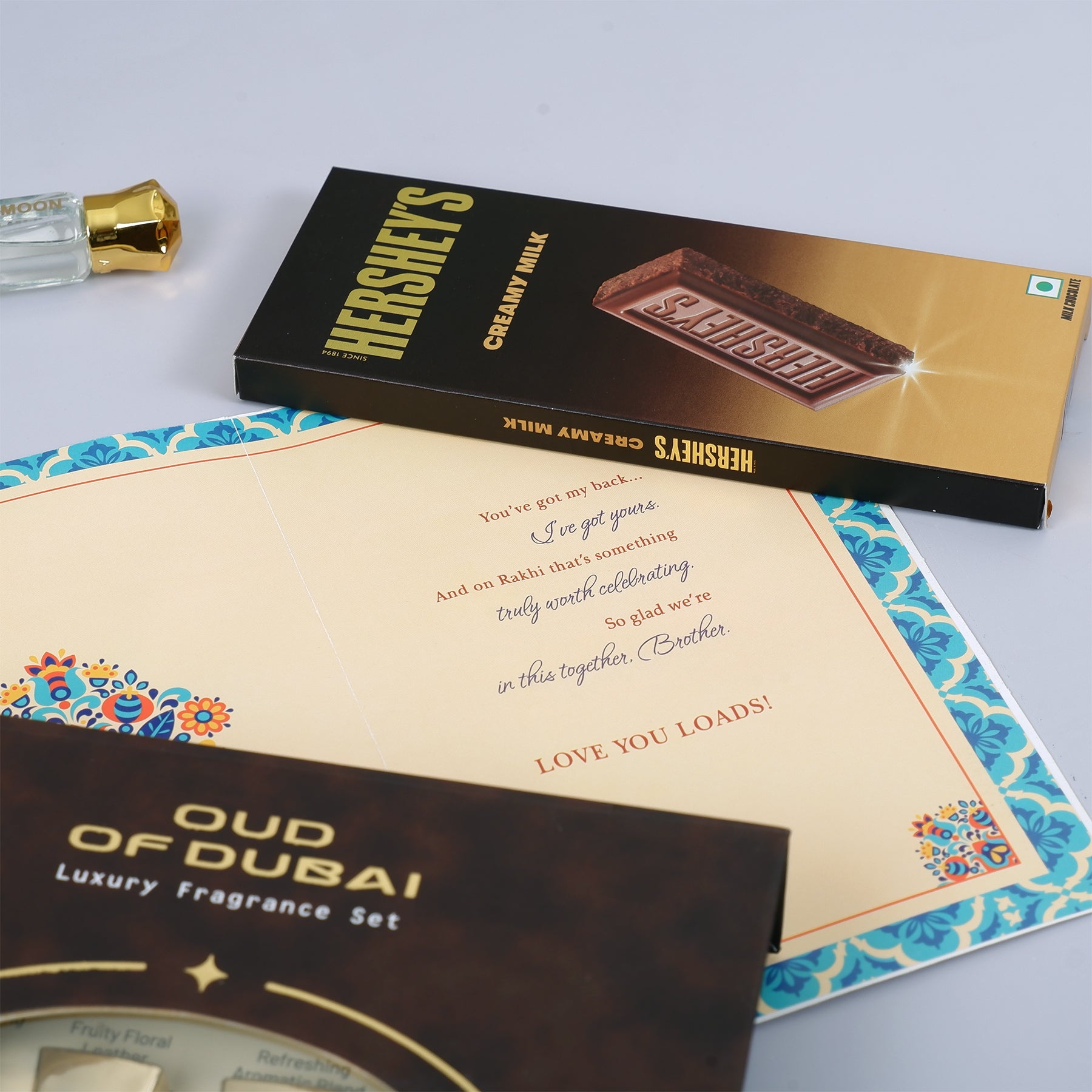 Oud Of Dubai Perfume with Rakhi Greeting Card and Hersheys Chocolate Bar