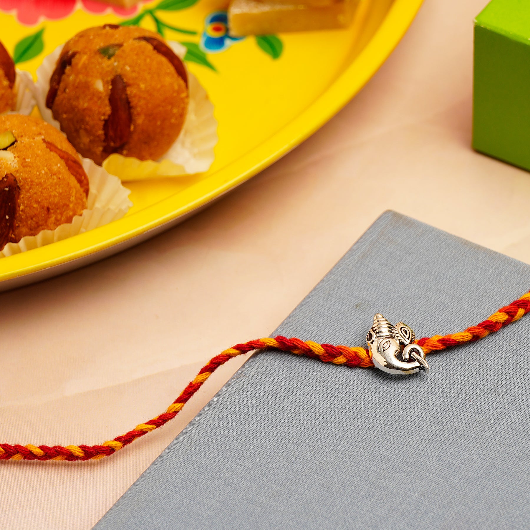 Sacred Ganesha Silver Rakhi with Besan Ladoo