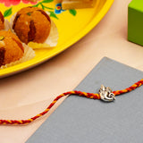 Sacred Ganesha Silver Rakhi with Besan Ladoo