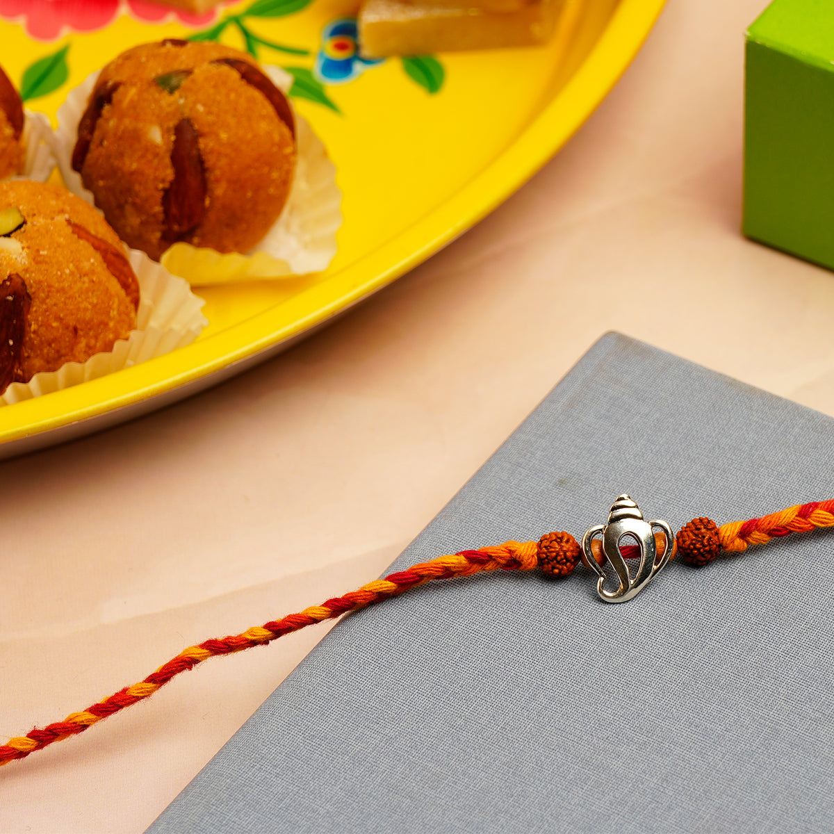Divine Ganesha Silver Rakhi with Besan Ladoo