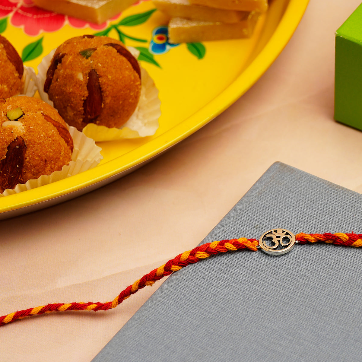 Shree OM Silver Rakhi with Besan Ladoo