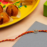 Shree OM Silver Rakhi with Besan Ladoo