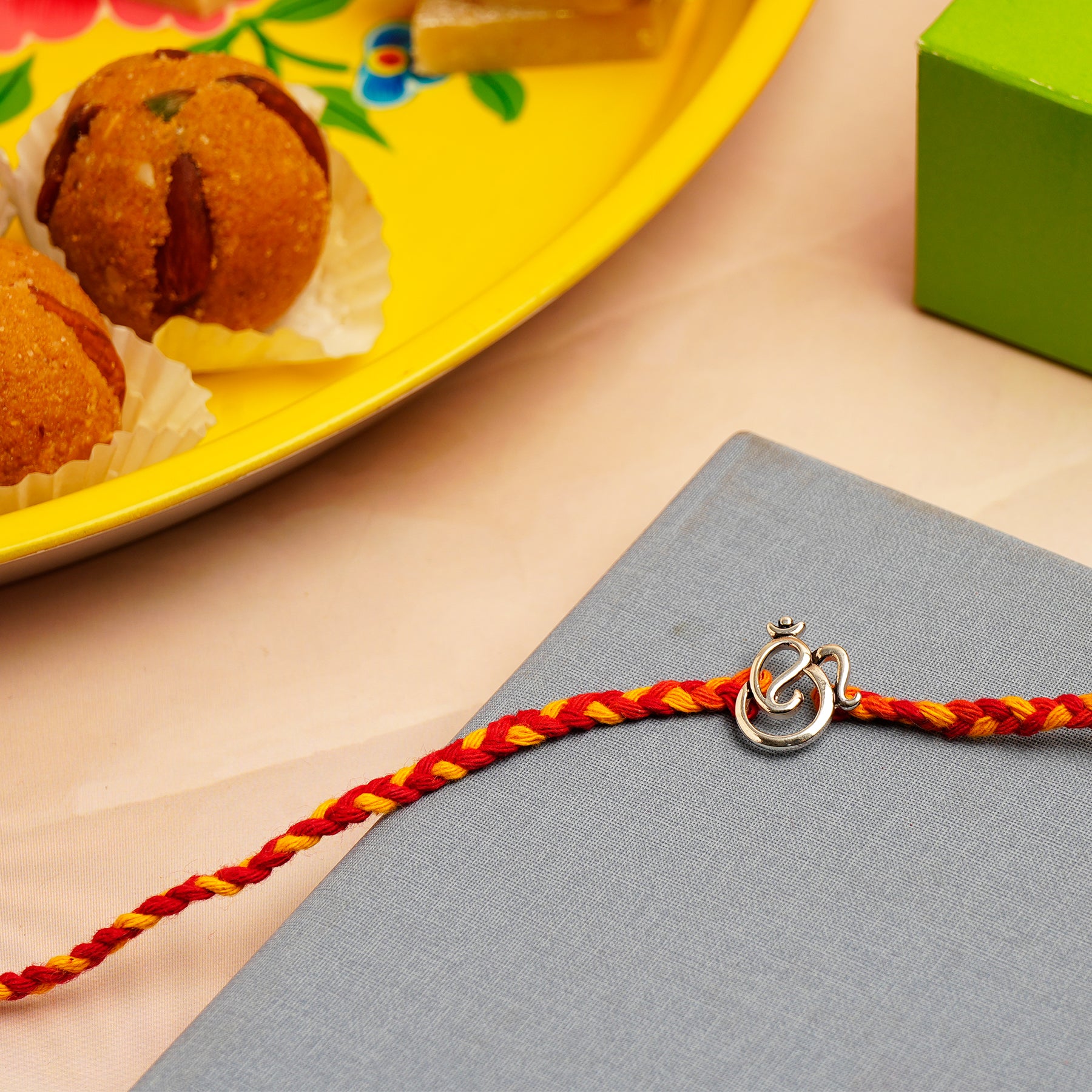 Om Ganesha Silver Rakhi with Besan Ladoo