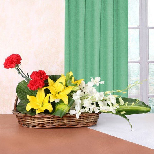 Basket Floral arrangement of 3 Yellow Asiatic Lilies, 4 Red Carnations, 4 White Orchids in Handle Basket